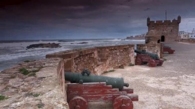 Fırtınalı Atlantik okyanusuna karşı güçlendirilmiş toplar ve eski kale duvarı Fas 'ın Essaouira şehrine çarpıyor..