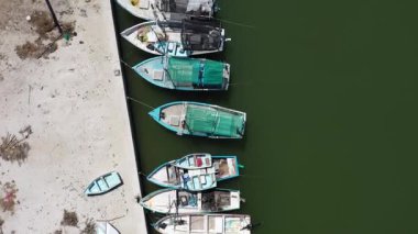 Aşağıya bakan hava manzarası ve Meksika limanındaki küçük ahşap balıkçı teknelerini gösteren kamera..