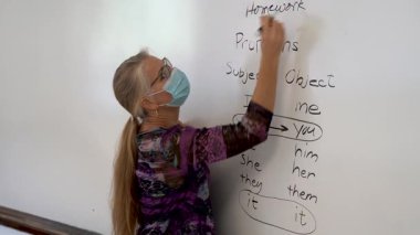 Gülümseyen olgun bir kadının yakından çekilmiş portresi. İngilizce öğretmeni, bir okul sınıfında beyaz tahtaya yaslanmış..