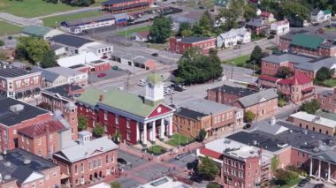 Experience a stunning aerial view of Main Street and the historic Jefferson County Courthouse in Charles Town on a sunny autumn day filled with vibrant colors.