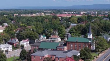 Fly over Charles Town, West Virginia, on a sunny autumn day, showcasing the charming Main Street and historic Jefferson County courthouse and community.