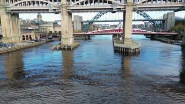 Tyne Nehri boyunca eryel insansız hava aracı uçuşu ikonik Tyne Köprüsü 'ne yükseliyor ve Newcastle' ın canlı rıhtımını ve ufuk çizgisini göstermek için köprünün etrafında dönüyor.