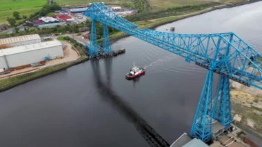 İkonik Middlesbrough Taşıyıcı Köprüsü 'nün altında küçük bir tekne yüzen insansız hava görüntüsü.
