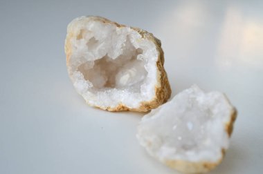 Bir kuvars jeotunun iki parçası, içindeki çarpıcı kristal iç mekanı ortaya çıkarıyor. Bölünmüş jeot, kuvars kristallerinin doğal güzelliğini ve karmaşık oluşumlarını vurguluyor. Bu da onu büyüleyici bir konu yapıyor.