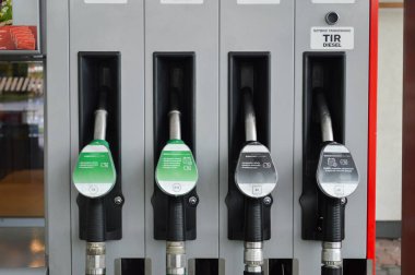 Benzin istasyonunda yakıt ikmali yapılan bir araba. Benzin ve dizelin artan maliyetini simgeliyor. Görüntü, yakıt ikmali sürecini vurguluyor ve günlük akaryakıt fiyatlarını etkileyen artışa odaklanıyor