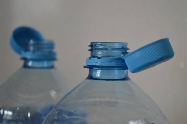 Çıkarılamaz kapaklı, modern şişe tasarımı ve işlevselliğini ön plana çıkaran iki plastik şişenin yakın çekimi. İçecek ambalajı, depolama ve yeniden kullanılabilir konteyner temaları için ideal.