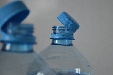 Çıkarılamaz kapaklı, modern şişe tasarımı ve işlevselliğini ön plana çıkaran iki plastik şişenin yakın çekimi. İçecek ambalajı, depolama ve yeniden kullanılabilir konteyner temaları için ideal.