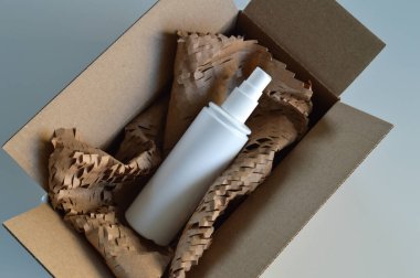 Koruyucu ambalaj malzemeleriyle dolu karton bir kargo kutusu, çevre dostu kağıt dolgu malzemesi ve biyolojik olarak çözünebilir fıstık paketleri de dahil. Bu malzemeler güvenli bir şekilde paketlemek, kırılgan eşyaları korumak ve güvenli bir şekilde teslim etmek için idealdir.