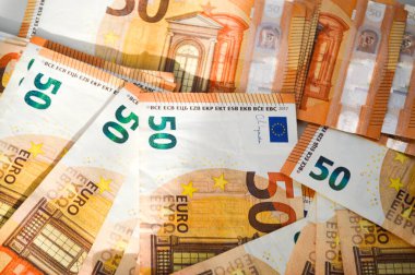 Çoğunluğu 50 Euro 'luk banknotlar halinde kaotik bir şekilde sergilendi. Para biriminin canlı detayları, renkleri ve güvenlik özellikleri görsel olarak çekici bir kompozisyon oluşturur. Finansal temalar, bankacılık, ekonomi, zenginlik için ideal