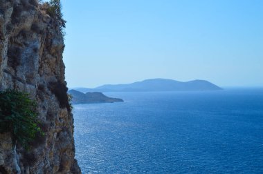 Yunanistan 'ın Rodos kentindeki antik Monolithos Şatosu' nun bir bölümünde, bu resim, arka planda Ege Denizi 'ni ve kıyı şeridini süpüren bereketli bir ormanın üzerinde duran kalenin yıpranmış taş duvarlarını yakalıyor. S Şövalyeleri tarafından inşa edildi.