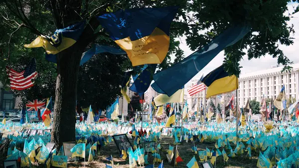 Ukrayna bayrakları rüzgarda dalgalanıyor. Cesaret. - Zafer. Yaşamın bedeli. Ukrayna 'nın bağımsızlık günü. Ukrayna - Ukrayna bayrakları ve çiçekleri.