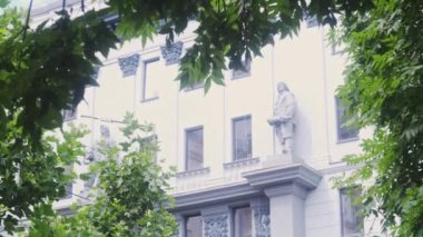 Eski binanın manzarası. Yeşil ağaçların arasında beyaz bina Yaz havasında bir yaz şehrinde.