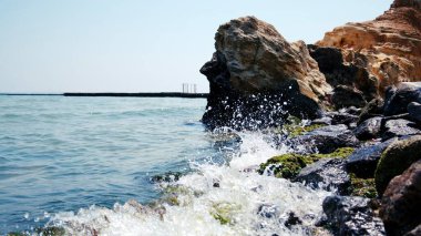 Taşları ve taşları olan deniz kıyıları. Taş gibi. Deniz. Taş dokusu. Kaya dokusu. Deniz Burnu. Güneşli bir hava. Deniz kayası. Denizin ortasındaki taş. Vahşi yaşam. Deniz doğası