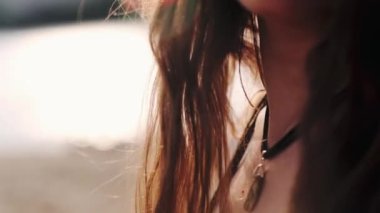 Uzun kahverengi saçlı, bulanık bir geçmişi olan güzel bir genç kadın.