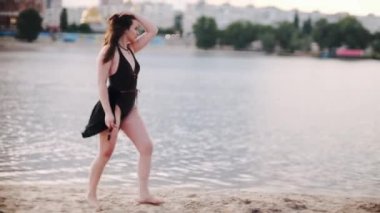 Nehirde poz veren siyah elbiseli genç bir kadın.