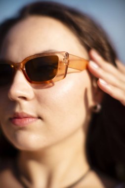 Güneş ışığıyla güneş gözlüklü kadın