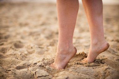 kadın ayakları kum plaj.