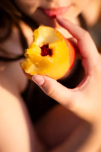 Bahçede kırmızı bir elma tutan güzel bir kadının portresini yakından çek.