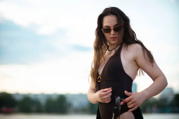 Siyah elbiseli, silahlı genç bir kadın.