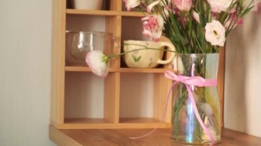 Masadaki vazoda bir buket beyaz lale. Çiçekçi çiçekleri budar. Vazoda güzel bir kompozisyon. Pembe çiçekler. Güzel kız. Hediye. Pastel renkler. Güzel bir iç mekan. Pembe güller. Eustoma. Şeffaf vazo. Sevgi. Yeşil. Makas.