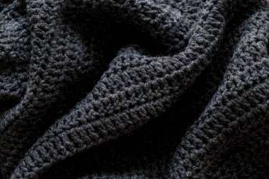 Gri örülmüş doku. Siyah kumaş arka plan. en üstteki görünüm