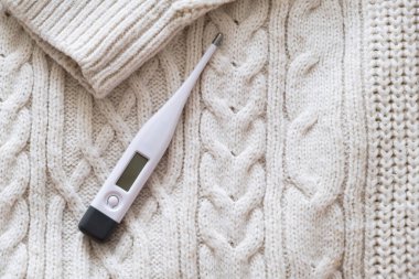 Beyaz termometreyi tutan kadın.