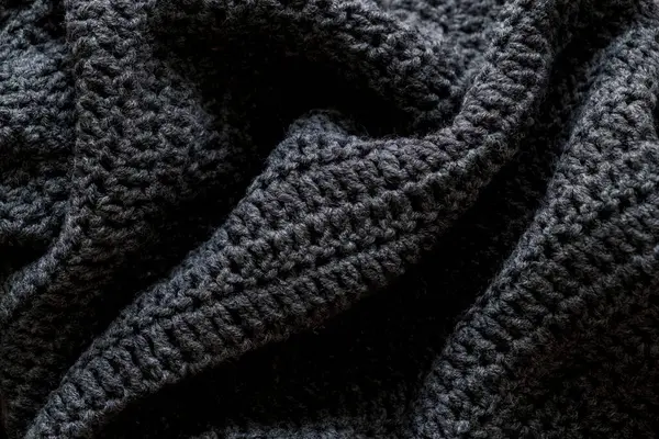 Gri örülmüş doku. Siyah kumaş arka plan. en üstteki görünüm