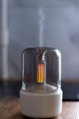 Hava nemlendirici. Aroma lambası. Yağlar. Minimalizm. Hava nemlendirmesi için minimalist lamba. Yatay fotoğraf. Reklam fotoğrafı. Meditasyon. Yanan lamba. Beyaz dava. Kablosuz aroma lambası