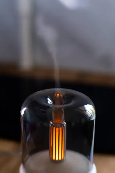 Hava nemlendirici. Aroma lambası. Yağlar. Minimalizm. Hava nemlendirmesi için minimalist lamba. Yatay fotoğraf. Reklam fotoğrafı. Meditasyon. Yanan lamba. Beyaz dava. Kablosuz aroma lambası