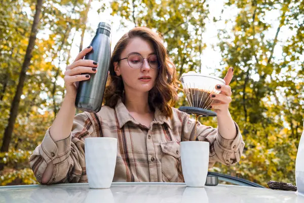 Sonbahar ormanında kadehli genç bir kız. Sonbahar seyahati. Kahve filtresi. Bir fincan kahve. Pişirme filtresi