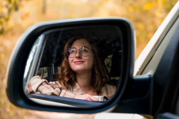 Araba vitrininde genç bir kadının portresi. sonbahar seyahati. 