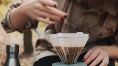 Güzel genç bir kadın bankta oturuyor ve kameraya bakıyor. Pişirme filtresi kahve