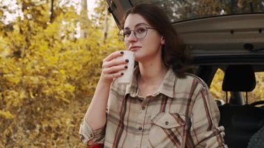 Arabada sırt çantası olan ekose gömlekli bir kız.