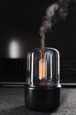Siyah hava nemlendirici. Ofis. Masaüstü. Aroma ayırıcı. Aroma lambası. Aroma yağı. Erkek işyeri. Bilgisayar. Hava nemlendirmesi. Nem seviyesi. Cihaz. Masaüstü akıllı aygıtı. Buhar