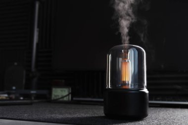 Siyah hava nemlendirici. Ofis. Masaüstü. Aroma ayırıcı. Aroma lambası. Aroma yağı. Erkek işyeri. Bilgisayar. Hava nemlendirmesi. Nem seviyesi. Cihaz. Masaüstü akıllı aygıtı. Buhar