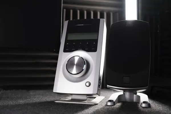 Koyu arkaplanda piyanonun yanında mikrofonu olan hoparlör