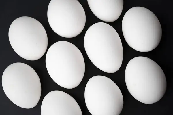 Siyah arka planda tavuk yumurtaları. Siyah masada dört yumurta. İki beyaz ve iki kahverengi yumurta. Yüksek kalite fotoğraf
