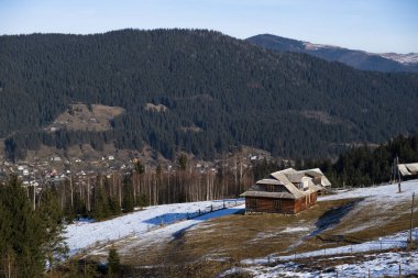 Kışın tepedeki ahşap ev.