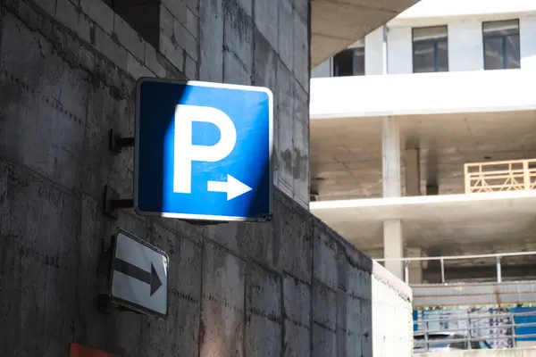 Beyaz duvarda park tabelası