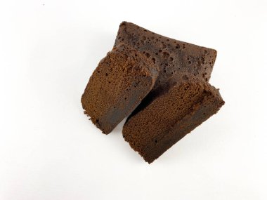 Koyu ve nemli bir pastanın birkaç diliminin yakın planında zengin ve parçalanmış bir doku var. Pasta beyaz bir arkaplanda düzenleniyor. Kek. Düz açılı kek.