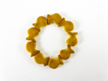 Beyaz arka planda düzenlenmiş balık şeklinde kraker çemberi. Mükemmel bir daire çizmişler.