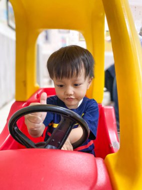 Asyalı bebek araba kullanıyor.