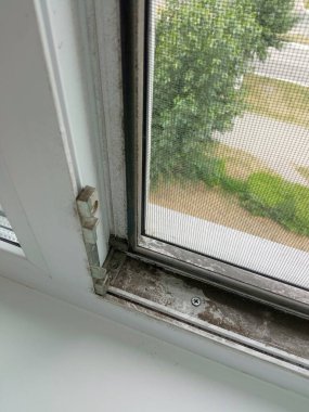 Kirli pencere. Kir, toz, ulaşılması zor yerlerde camda is. Yıkanmamış plastik pencereler yakın plan. Genel temizlik. Metin için arkaplan, yer.