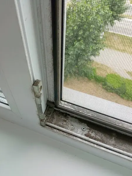 Kirli pencere. Kir, toz, ulaşılması zor yerlerde camda is. Yıkanmamış plastik pencereler yakın plan. Genel temizlik. Metin için arkaplan, yer.