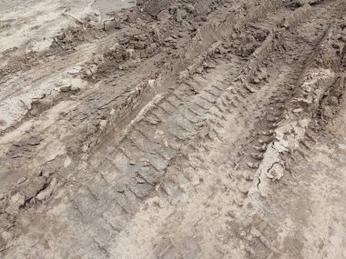 Yoldaki çukurlar. Yolların saldırmazlığı. Şiddetli yağmurdan sonra yollar. Bulanık bir yol. Konsept, arabaların tekerleklerinin çamura saplanması. Yerde traktör izleri var..