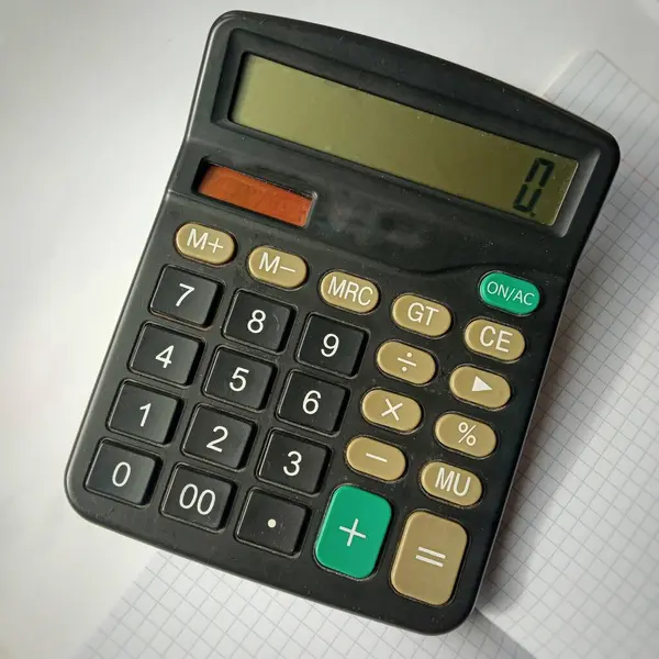 Hesap makinesi masanın üzerindedir. Hesap makinesindeki 0 sayısı. Küçük gelir, iflas, kriz. Küçük bir maaş..