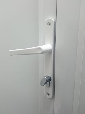 Tuvaletteki plastik kapı. Plastik kapı kolu ve kapı kilidi. Umumi tuvalet. Plastik balkon kapısı. Metin için arkaplan, yer.