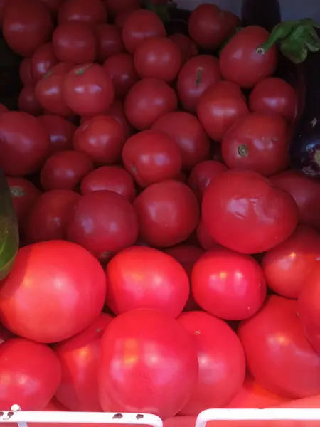 Kutuda kırmızı domates. Salata ve domates sosu için domates alma fikri. Süpermarkette pembe domatesler. Bir sürü domates. Geçmişi. Doğal bir fotoğraf..