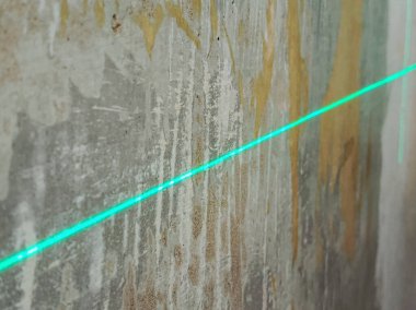 Duvarların hizalanması lazer seviyesine göre. Duvarları yıkmak ve işaretlemek için bir lazer ışını. Dairenin tadilatı. Arka plan, mesaj için yer. Lazer seviyesi.