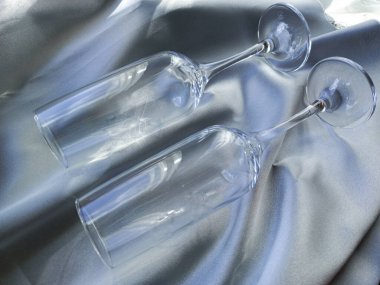 Gri ipek üzerine iki bardak. Gümüş ipek kumaşa çift gözlük takmış. Düğün hediyesi, yıldönümü. Şarap kadehi..